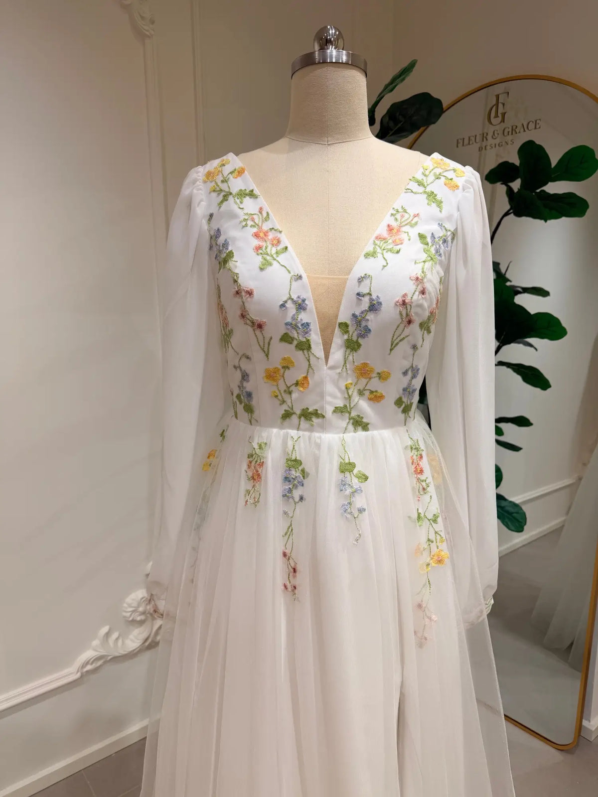 Stacey A-line wedding dress with pastel floral embroidery, deep V-neck, and airy chiffon bishop sleeves on tulle.