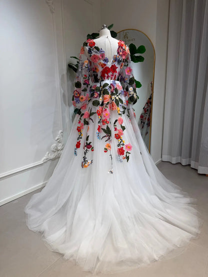 Back view of a white tulle wedding dress with vibrant floral embroidery, long bishop sleeves, and an illusion V-back.