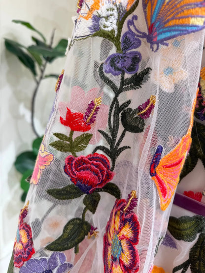 Sheer tulle wedding dress sleeve featuring vibrant, multi-colored 3D floral embroidery and butterfly accents.