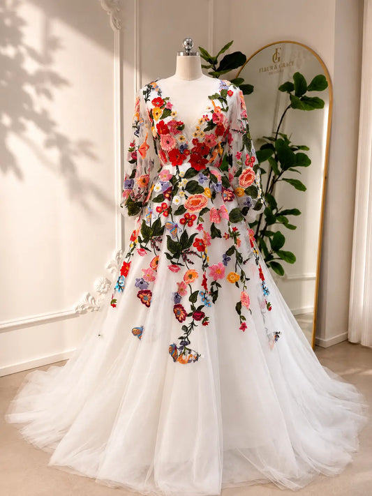 Suri A-line wedding dress with vibrant floral embroidery, long bishop sleeves, and an elegant illusion V-neckline.