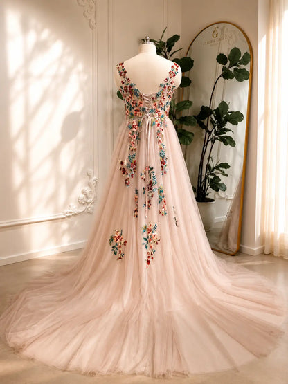 Blush A-line wedding dress with colorful floral embroidery, illusion V-back, and adjustable corset lace-up closure.