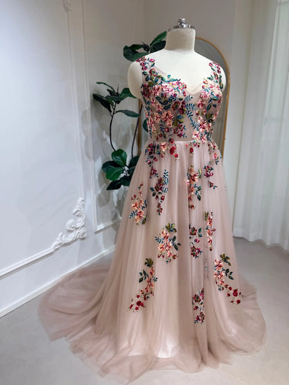 Blush A-line wedding dress featuring colorful floral embroidery, an illusion sweetheart neckline, and a flowing tulle skirt.