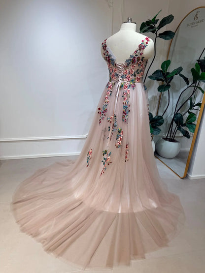 Blush tulle wedding dress with colorful floral embroidery, illusion V-back, and adjustable corset lace-up closure.