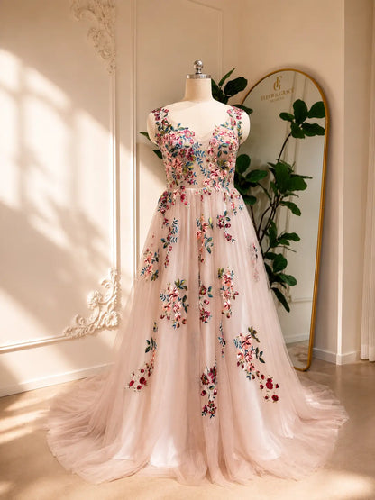 Blush A-line wedding dress featuring colorful floral embroidery, an illusion sweetheart neckline, and flowing tulle skirt.