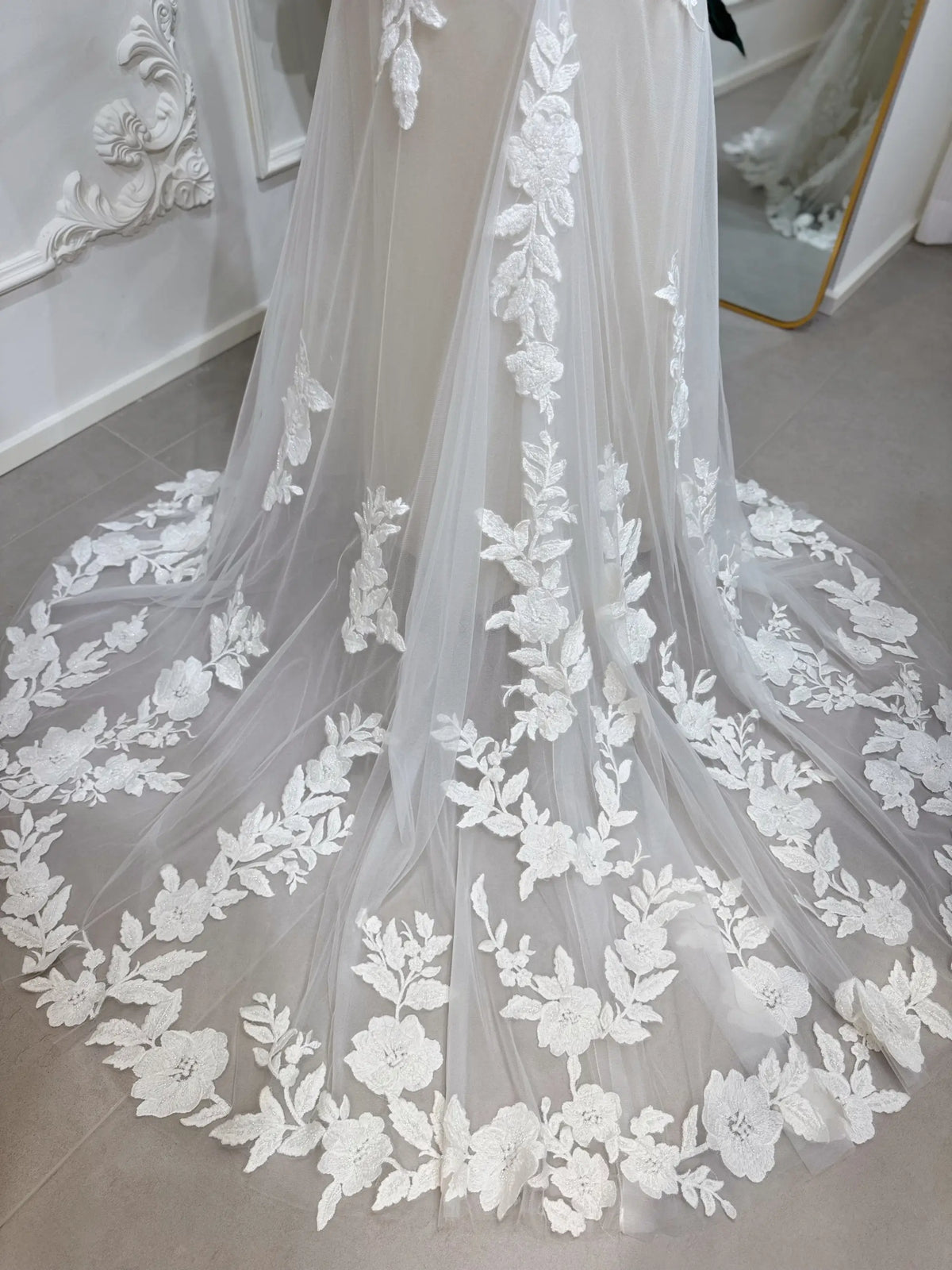 Ivory floral lace wedding dress with a court-length train and beige silk lining, featuring intricate beaded embroidery.