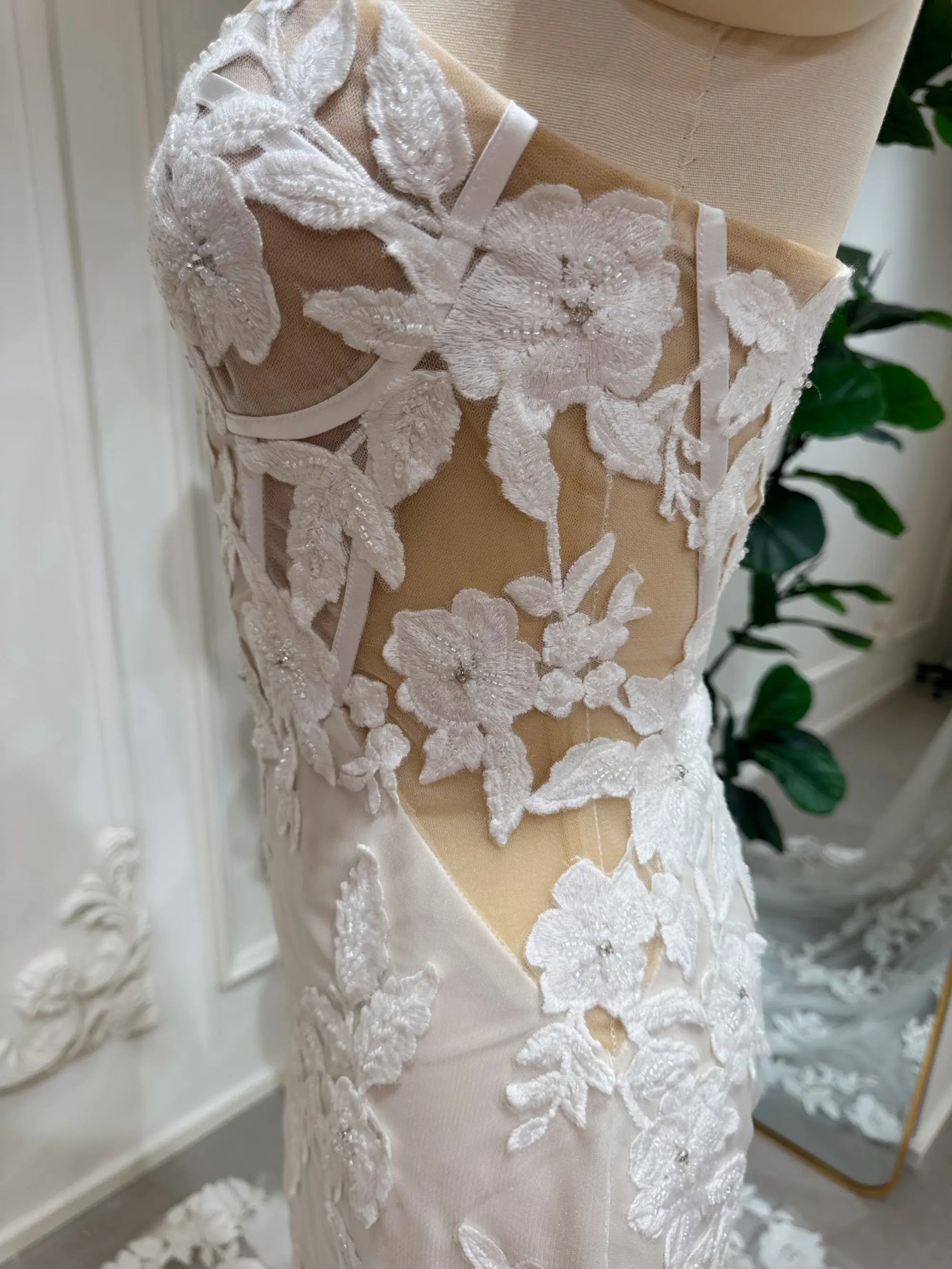 Tia Gown  by Fleur&Grace Designs — strapless mermaid wedding dress with basque waistline, sheer boned bodice, beige silk lining, ivory floral embroidery with beading, plunging V-neck, and court train.