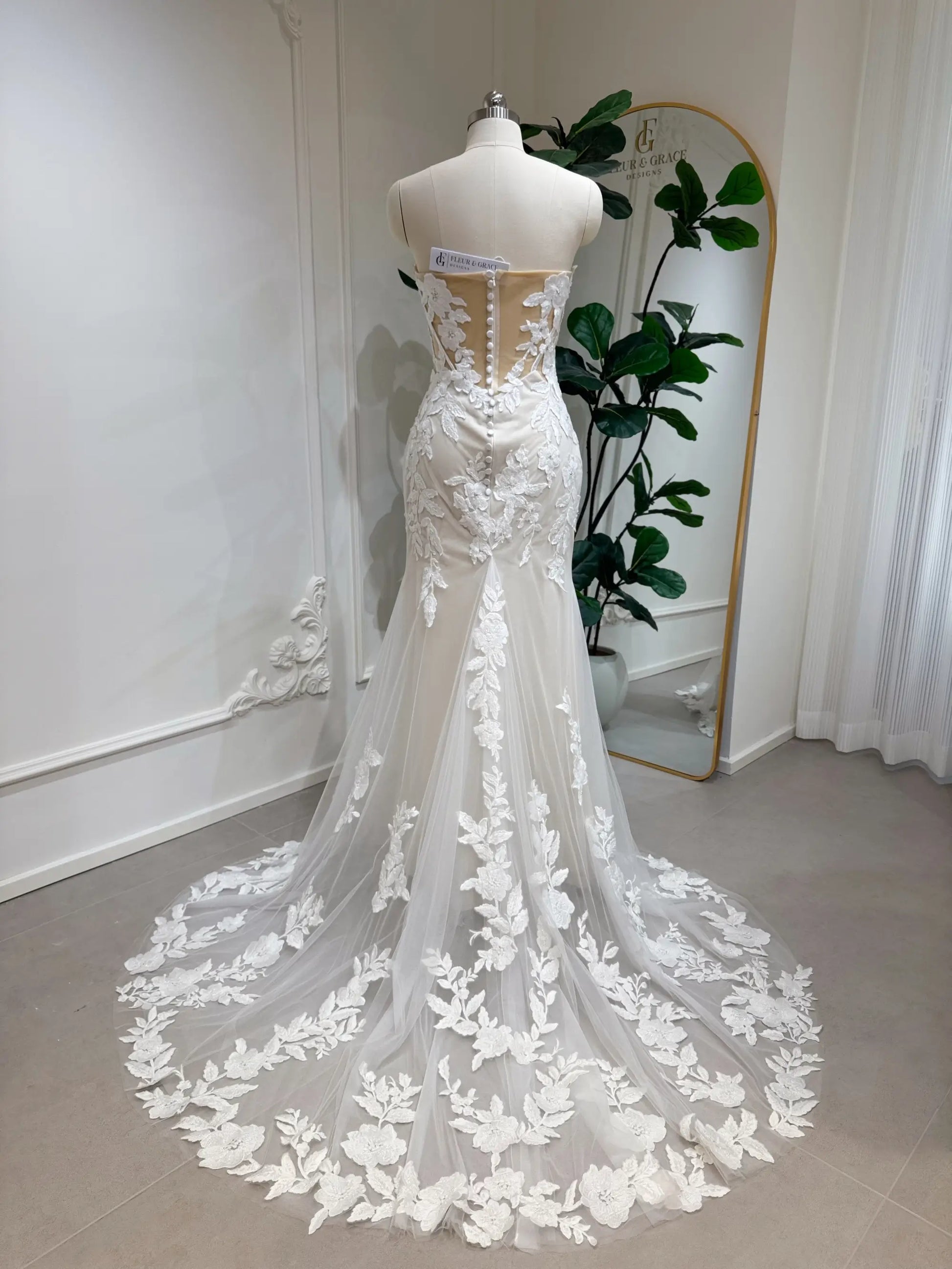 Tia Gown  by Fleur&Grace Designs — strapless mermaid wedding dress with basque waistline, sheer boned bodice, beige silk lining, ivory floral embroidery with beading, plunging V-neck, and court train.