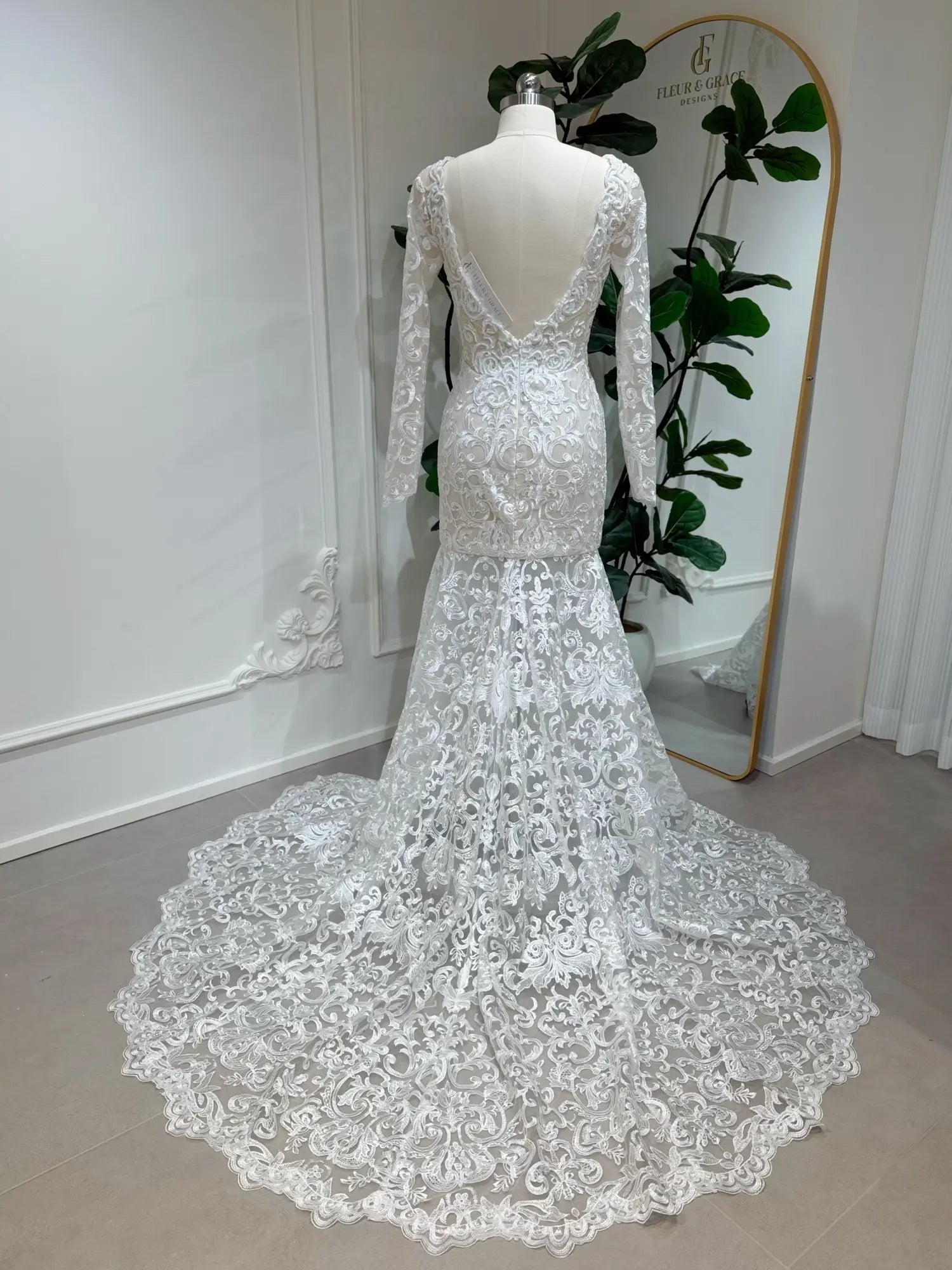 Beaded lace mermaid wedding dress with long sleeves, deep V-back, and a dramatic scalloped chapel train.