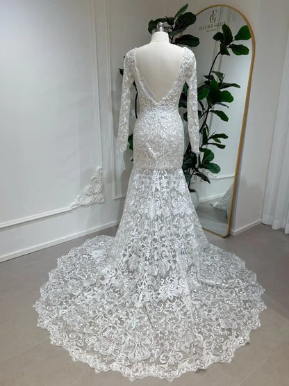 Beaded lace mermaid wedding dress with long sleeves, deep V-back, and a dramatic scalloped chapel train.