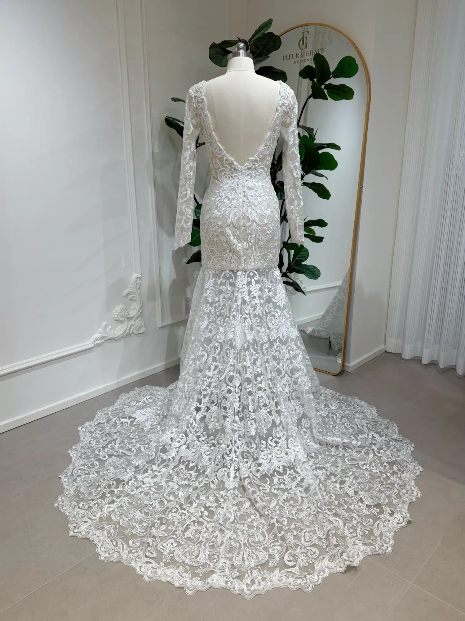 Beaded lace mermaid wedding dress with long sleeves, deep V-back, and a dramatic scalloped chapel train.