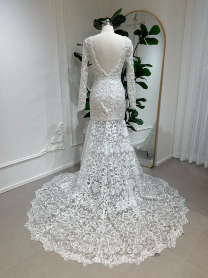 Beaded lace mermaid wedding dress with long sleeves, deep V-back, and a dramatic scalloped chapel train.