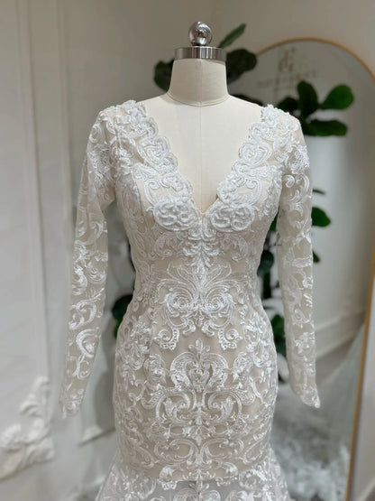 Beaded lace mermaid wedding dress with illusion long sleeves, V-neckline, and intricate embroidery on nude lining.