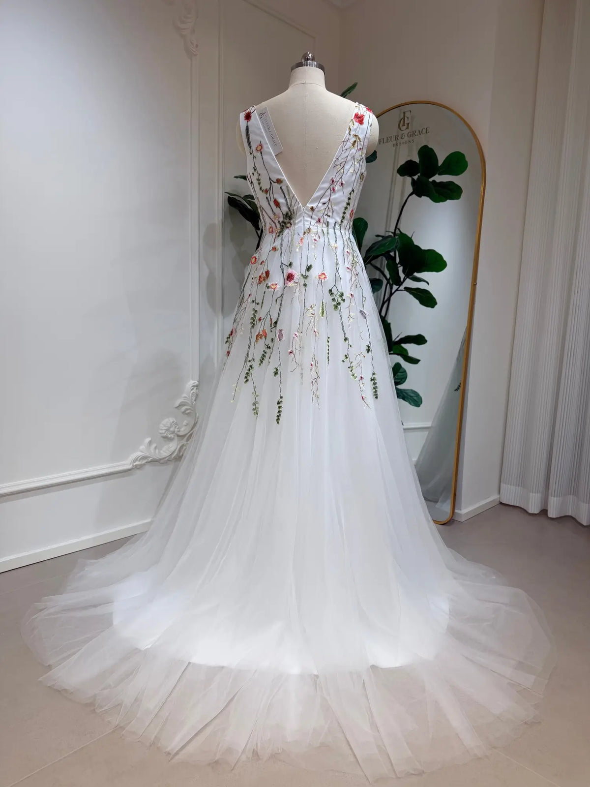 Viola A-line wedding dress with a low V-back, featuring delicate pink and sage floral embroidery on airy white tulle.