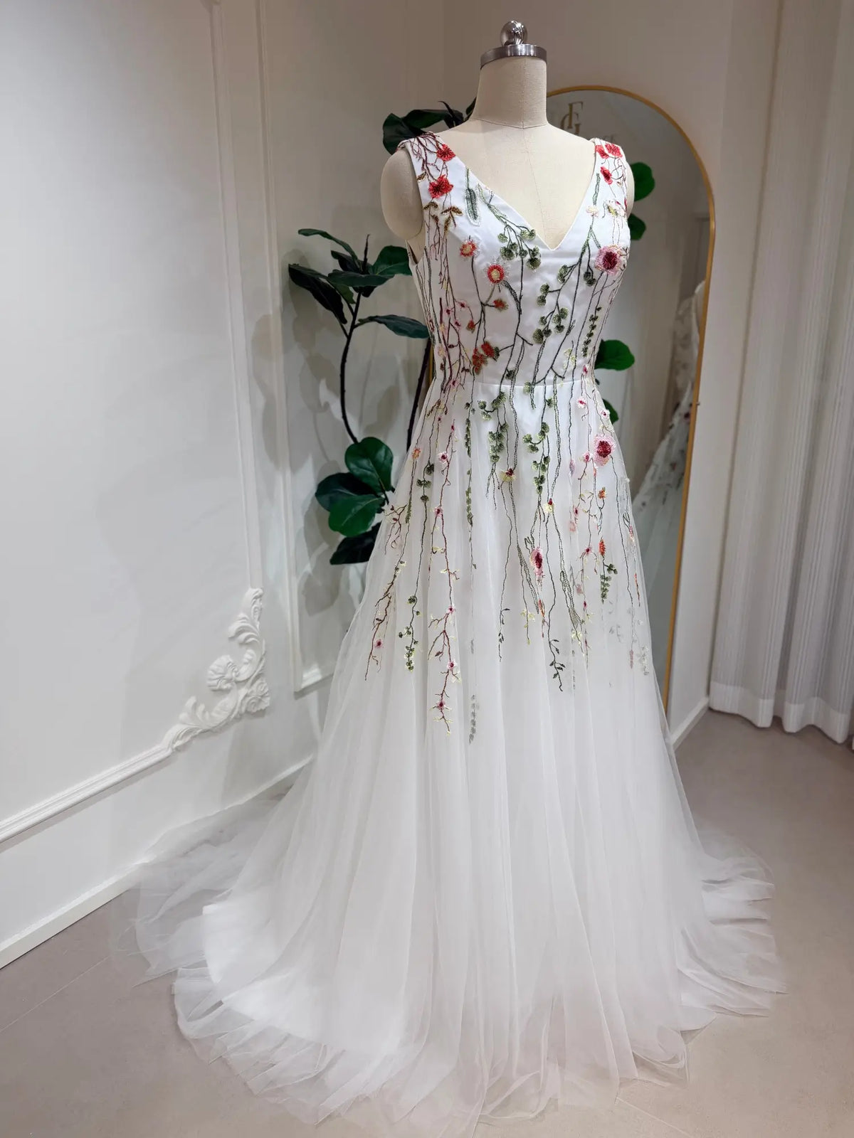 Viola A-line wedding dress with V-neck, featuring delicate pink and sage floral embroidery on airy white tulle.