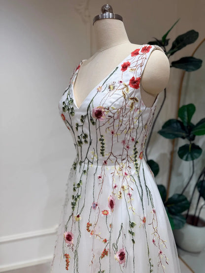 Viola A-line wedding dress with V-neck, featuring delicate pink, coral, and sage green botanical embroidery on soft tulle.