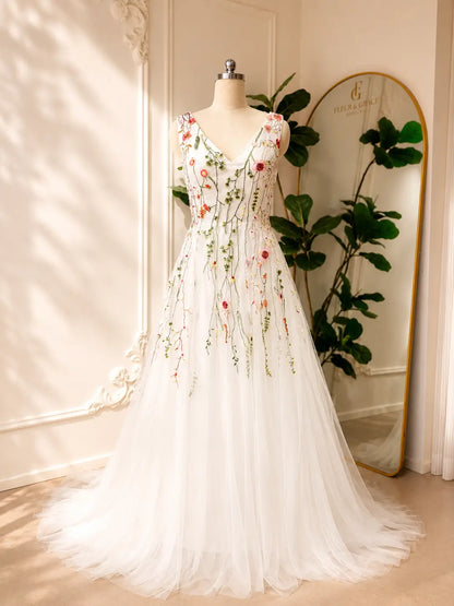 Viola A-line wedding dress with V-neck, tulle skirt, and colorful botanical floral embroidery on a satin bodice.