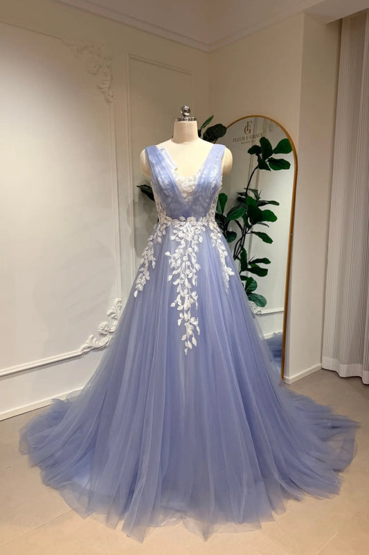 Dusty blue A-line wedding gown in tulle with a deep V-neck and intricate white floral lace appliqué on the bodice.
