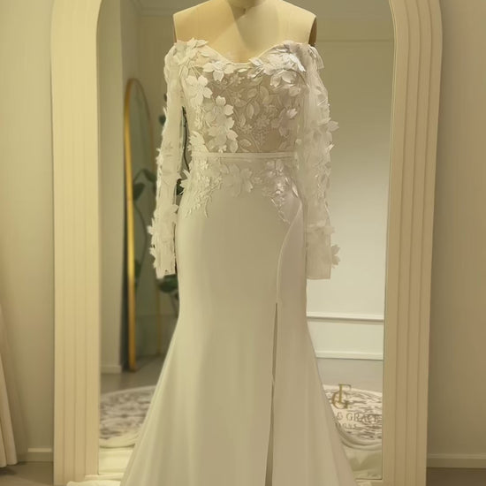 Zoe Gown by Fleur&Grace – minimalist matte crepe wedding dress with 3D floral lace bodice, long off-the-shoulder sleeves, side slit, and train, perfect for modern and romantic weddings.