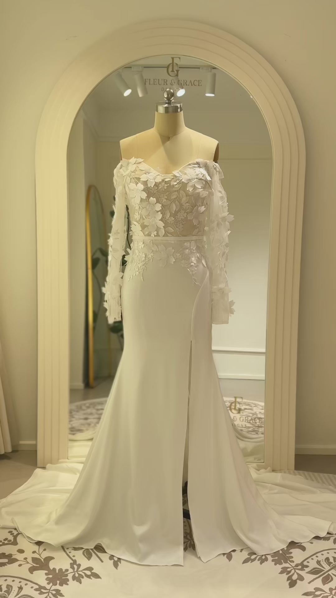 Zoe Gown by Fleur&Grace – minimalist matte crepe wedding dress with 3D floral lace bodice, long off-the-shoulder sleeves, side slit, and train, perfect for modern and romantic weddings.