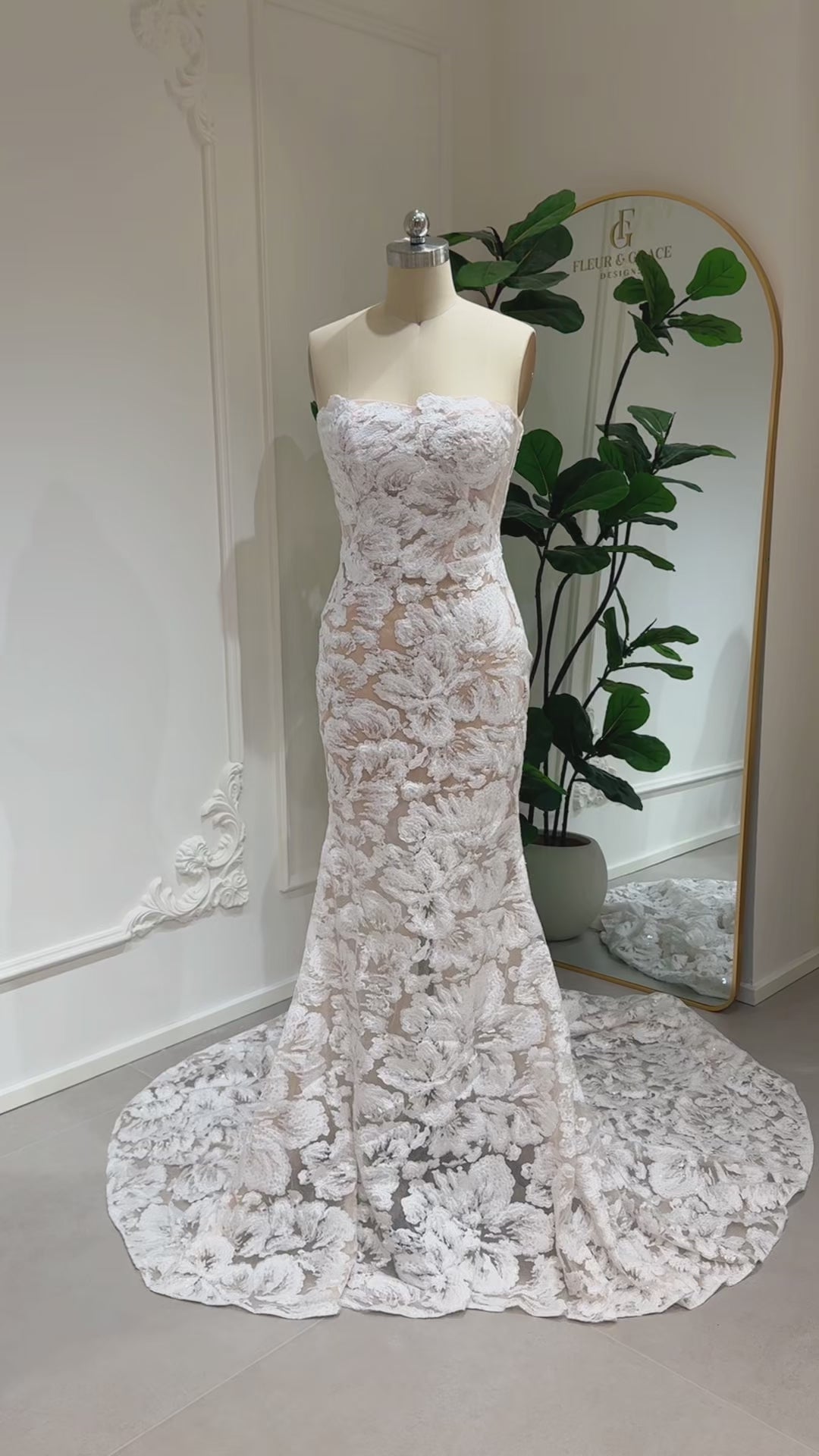 Mannequin wearing the Jane Gown by Fleur&Grace Designs – strapless mermaid wedding dress with floral embroidered lace, glitter sequins, lace‑up back, and chapel‑length train.
