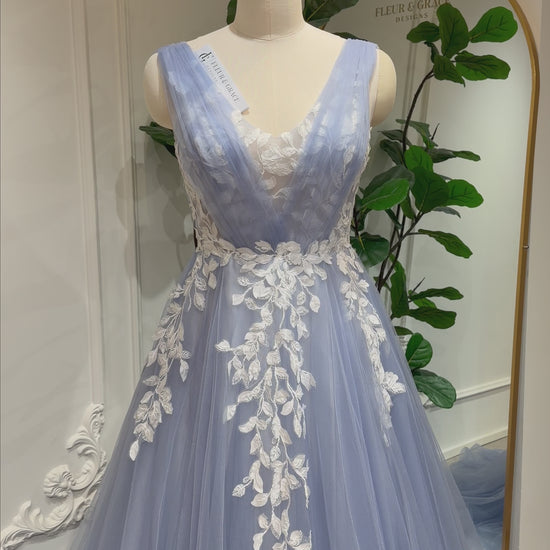 Zola dusty blue wedding dress with floral lace appliqué, deep V-neck & flowing tulle A-line skirt. Custom size available.