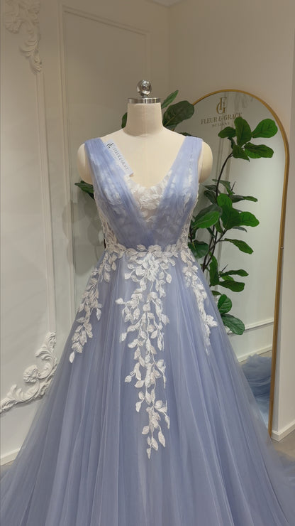 Zola dusty blue wedding dress with floral lace appliqué, deep V-neck & flowing tulle A-line skirt. Custom size available.