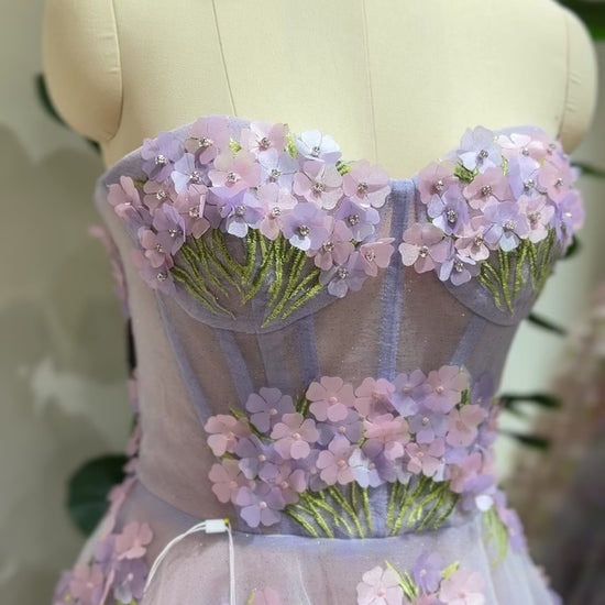 Model wearing the Lavender Elysia Gown FG016 by Fleur&Grace Designs – floor-length lavender dress with 3D hydrangea floral lace, sparkly mesh lining, and lace-up back, perfect for prom, garden weddings, formal evenings, and whimsical photography.
