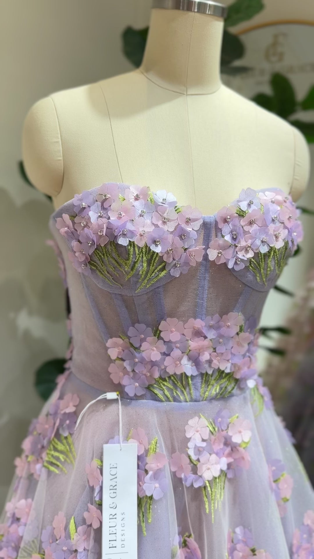 Model wearing the Lavender Elysia Gown FG016 by Fleur&Grace Designs – floor-length lavender dress with 3D hydrangea floral lace, sparkly mesh lining, and lace-up back, perfect for prom, garden weddings, formal evenings, and whimsical photography.